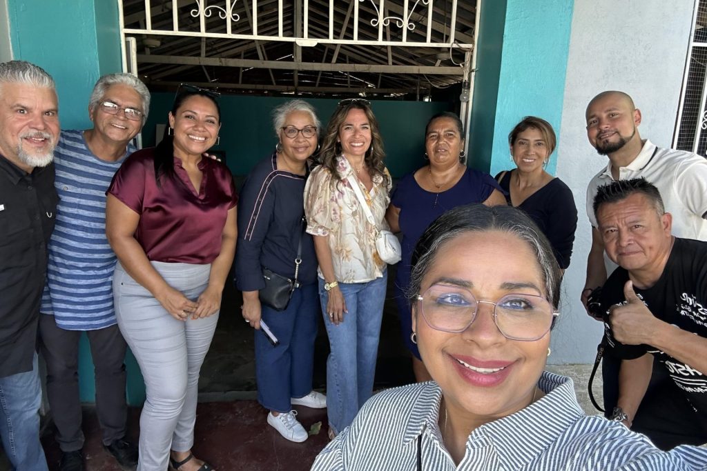 Mission team and local church members outside a turquoise church in Costa Rica
